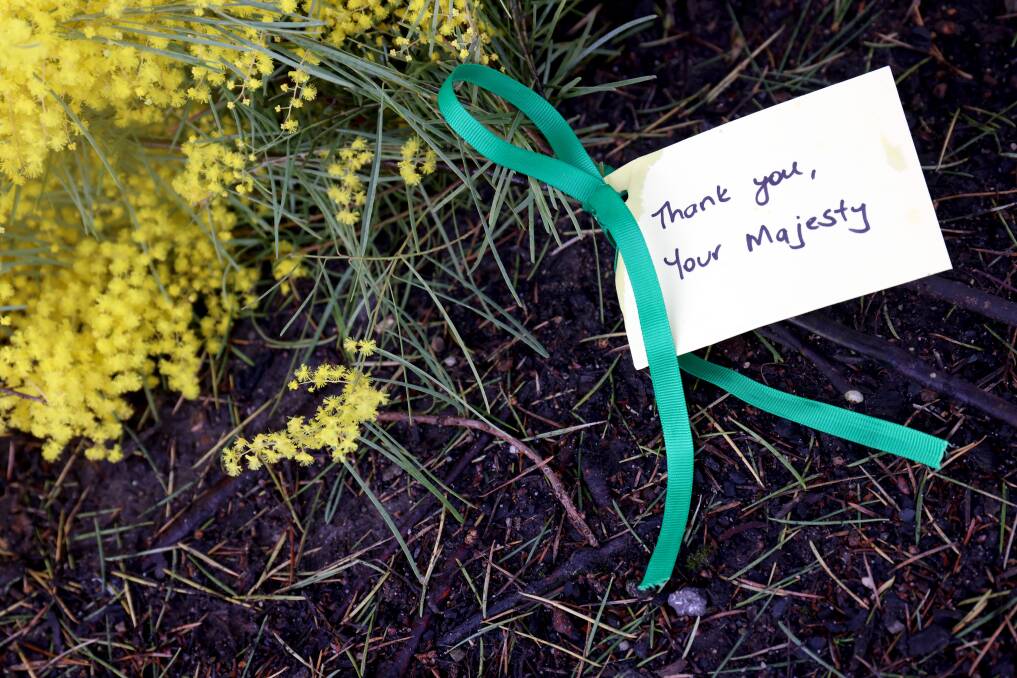 Kristy McNichol, of Curtin, and her children Catherine, 10, and Andrew Raether left this bouquet of wattle at Government House. Picture by James Croucher