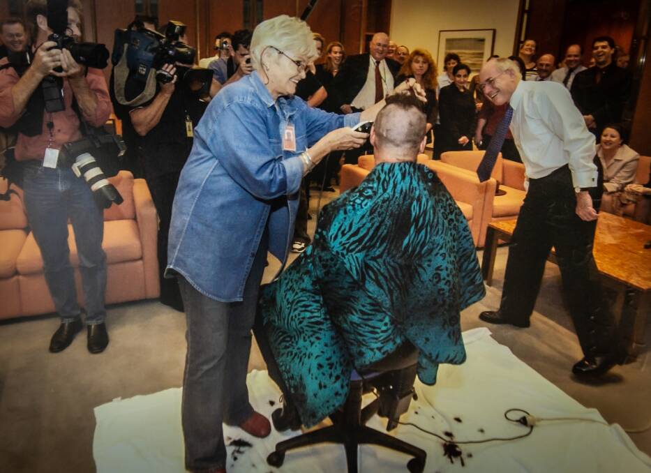 Lizzie Scott shaves the hair of Josh Frydenberg for charity when he was a staffer for prime minister John Howard. Picture: Supplied