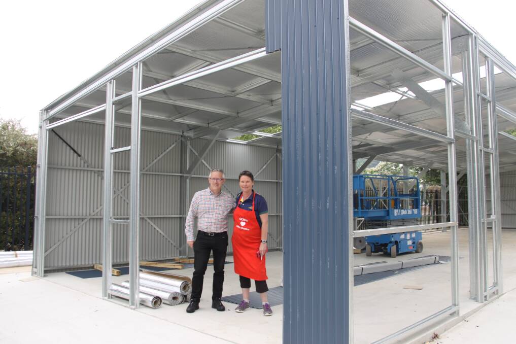 David Smith MP and a Woden Little Athletics Club volunteer in the shed, which is under construction, on Saturday. Picture: David Mackay