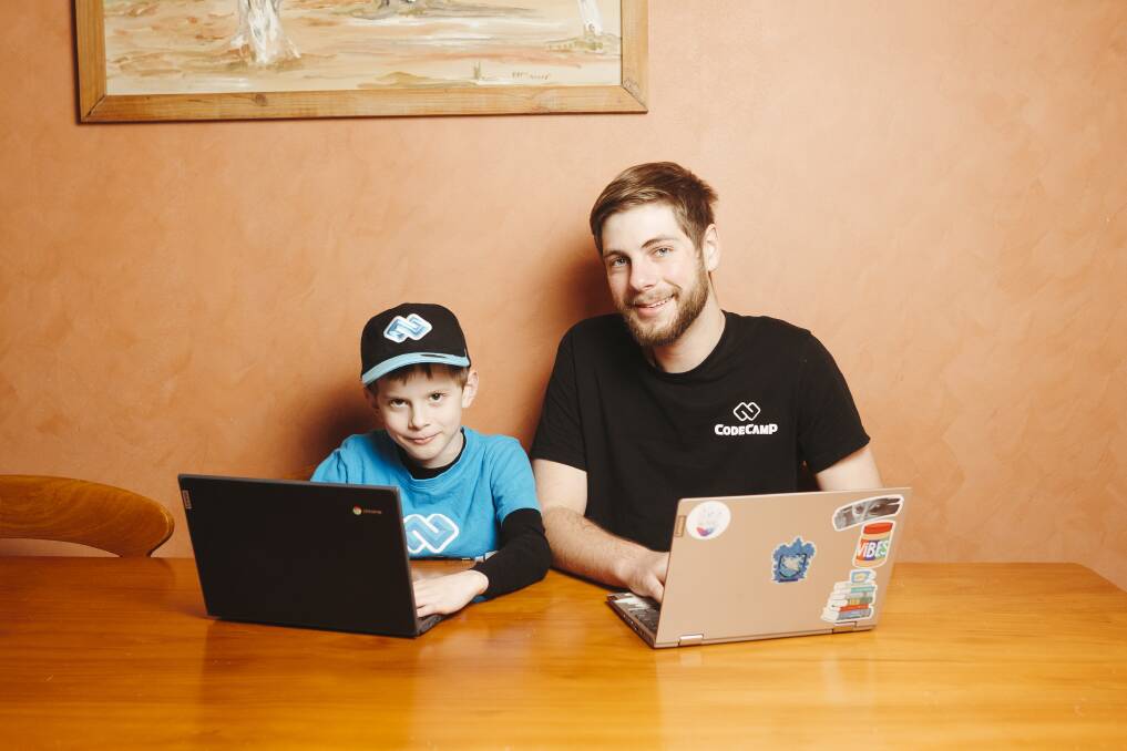 Code Camp teacher Lawrence Bowler with one of his students Samuel, 8, who is learning to code during the school holidays. Picture: Dion Georgopoulos
