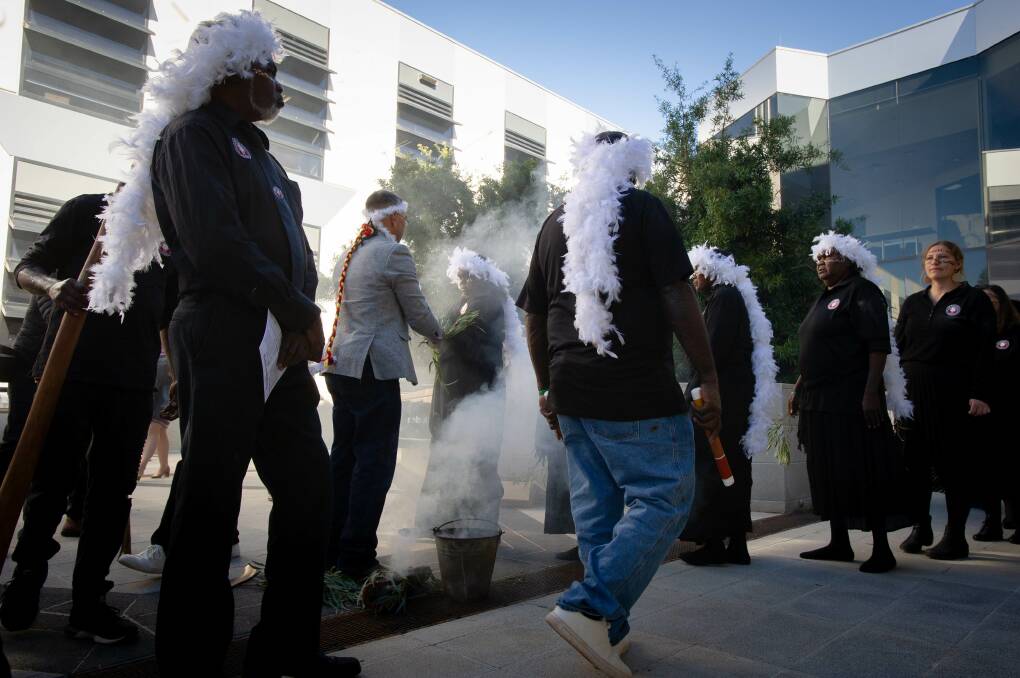 Paul House holds a smoking ceremony with Galiwin'ku community members. Picture: Elesa Kurtz