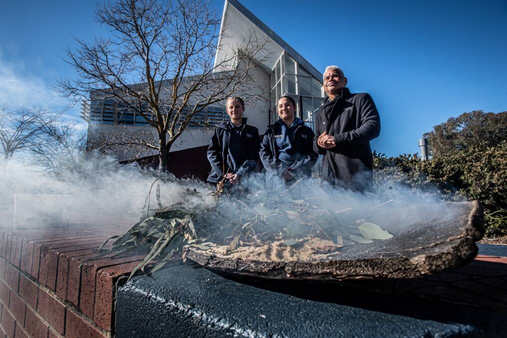 Gold Creek High School house captains Daisy Connor and Krystal Hernandez and Rork Projects co-owner John Janke attend a smoking ceremony before construction begins on the expansion project. Picture: Karleen Minney