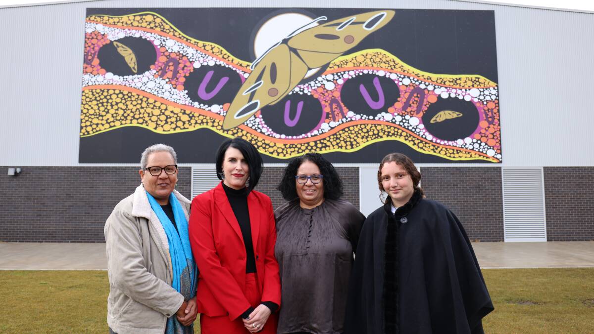 Evelyn Scott School principal Jackie Vaughan (second from left), and Charmaene, Katherine and Kristine Scott stand in front of a mural by Lynnice Church. Picture: James Croucher