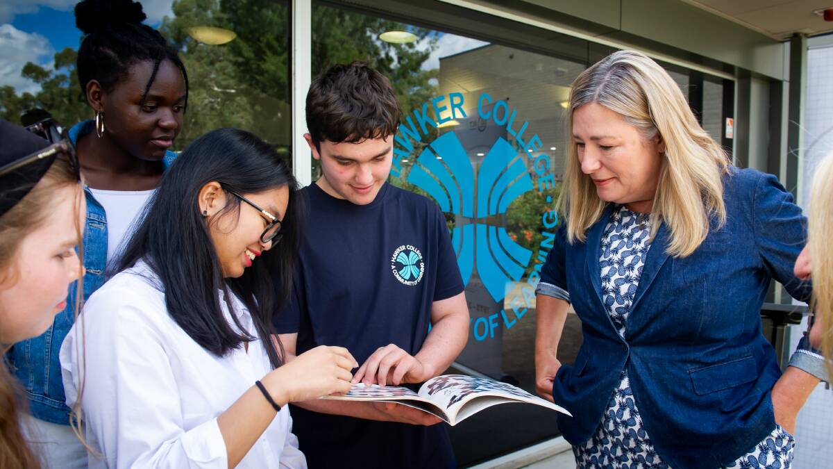 Education Minister Yvette Berry shows Hawker College students her yearbook.