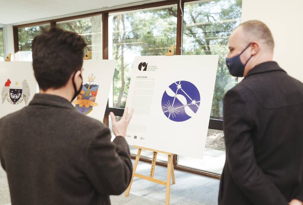 Liam Atkins, left, talks to Chief Minister Andrew Barr about his design for a coat of arms at the University of Canberra on Wednesday. Picture: Dion Georgopoulos