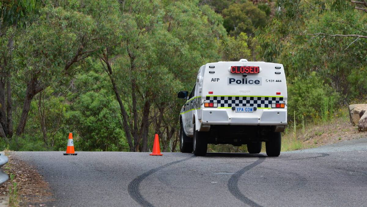 Police have blocked off Kambah Pool Road as a search continues on Saturday afternoon for a man missing believed drowned. Picture: Elesa Kurtz