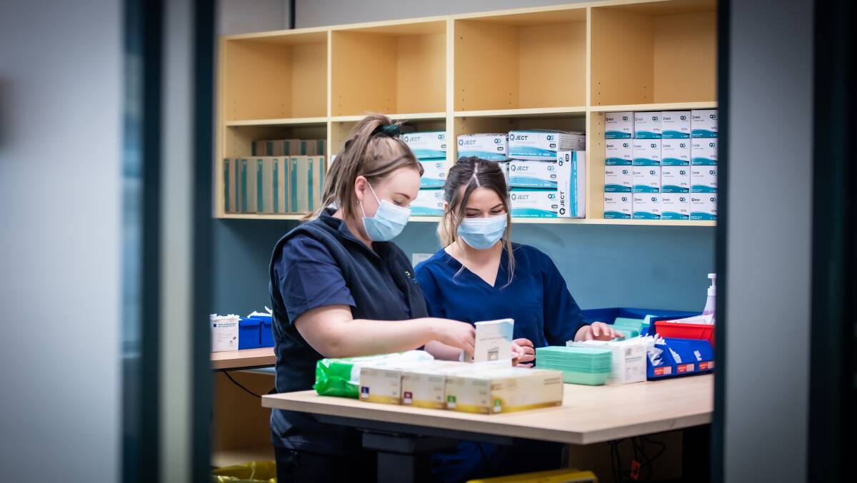 Clinical nurse manager Felicity Manson, left, and senior nurse Siobhan Nurmi check vaccine stocks at the Canberra Airport mass vaccination clinic. Picture: Karleen Minney