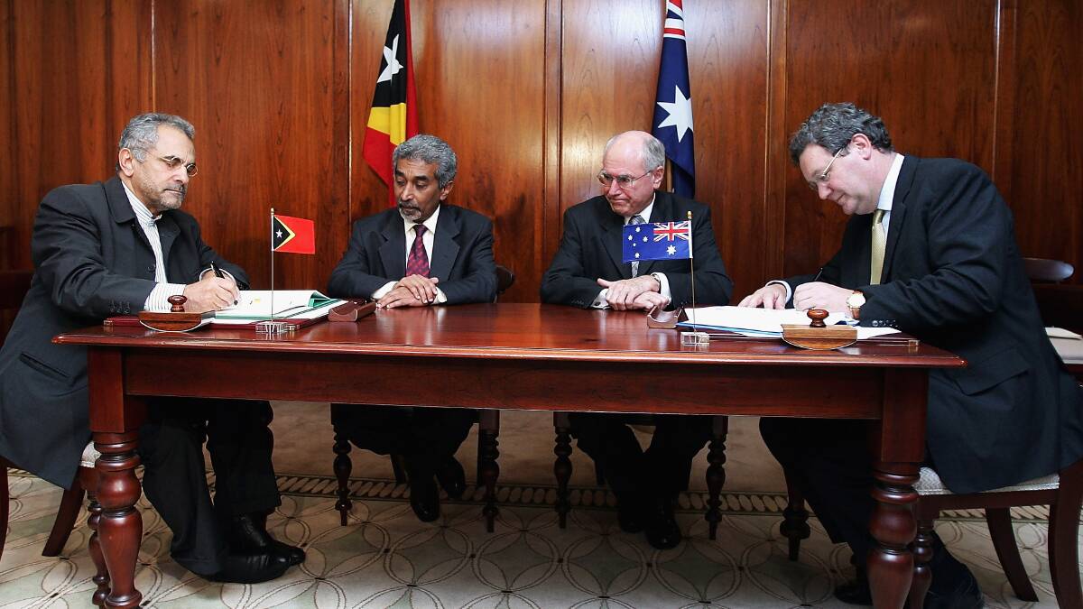 Then Australian foreign minister Alexander Downer (right) and East Timor minister for foreign affairs and co-operation Dr Jose Ramos-Horta (left) sign the treaty on maritime arrangements in the Timor Sea, as Australian prime minister John Howard and East Timor prime minister Mari Alkatiri look on in January 2006 in Sydney. Picture: Getty Images