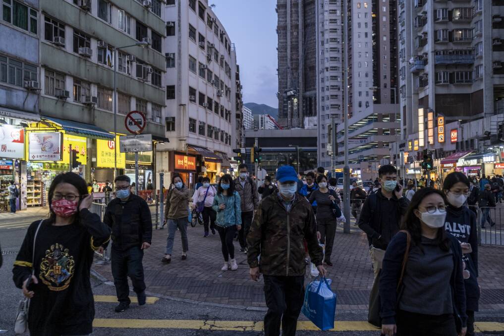 Pedestrians walk the streets of Hong Kong during the week wearing face masks to guard against coronavirus. Picture: Getty