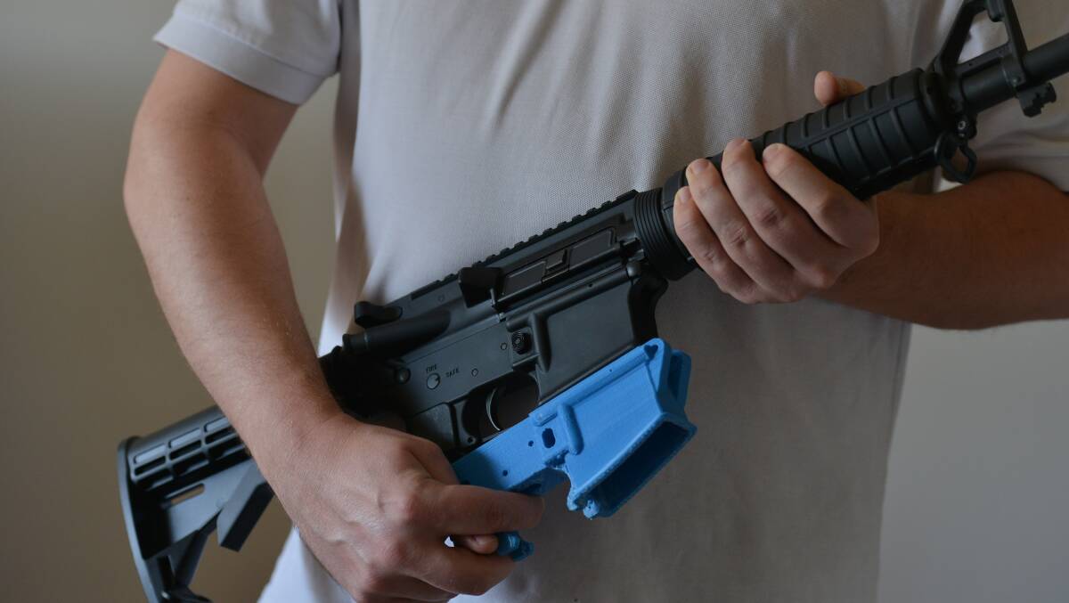 A US gun owner with an assault rifle and a part created with a 3D printer.