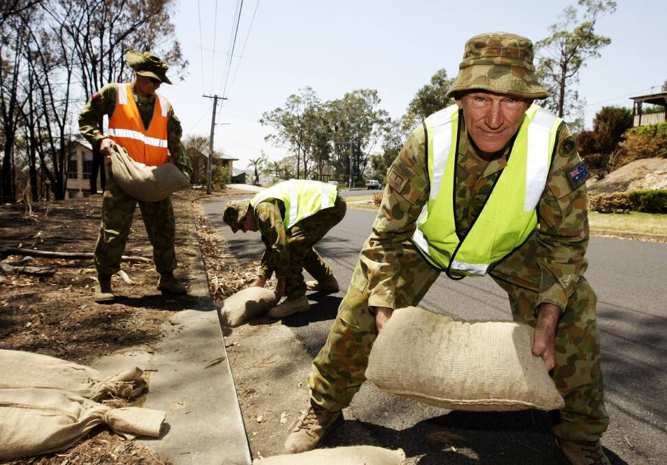 Lance Corporal Peter Elliott of the 5th Combat Engineering Regiment helps to sandbag residential drains to prevent asbestos and other harmful substances from being washed into the sewers during bushfire recovery support. Picture: Department of Defence
