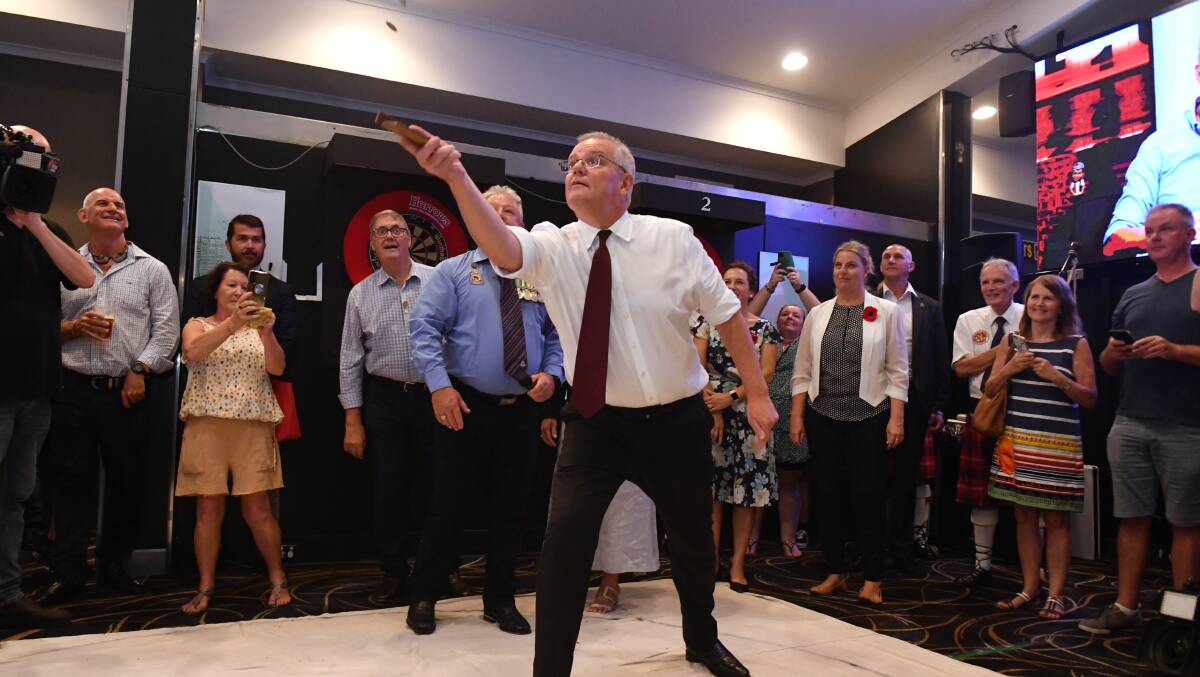 Scott Morrison plays two-up on Anzac Day at Cazalys Palmerston Club. Picture: AAP