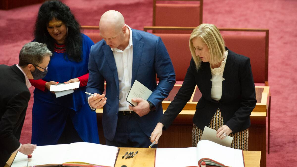 Senators for the ACT and Northern Territory, including Malarndirri McCarthy, David Pocock and Katy Gallagher, sign the senators' roll after being sworn in on Monday. Picture: Elesa Kurtz