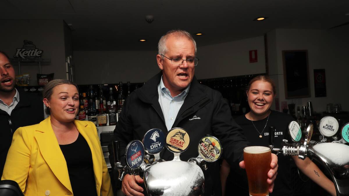 Prime Minister Scott Morrison pours beers for the patrons at at the Edgeworth Tavern, Newcastle, while campaigning in the Hunter Valley on Wednesday. Picture Peter Lorimer