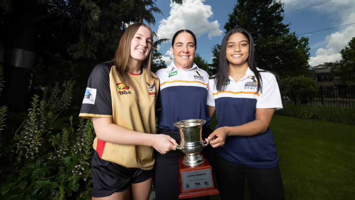 Brumbies front-rower Louise Burrows presents the Cup named in her honour to Daramalan duo April Downey and Gislea Vea. Picture: Sitthixay Ditthavong