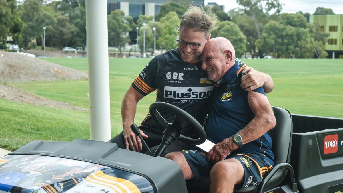 Brumbies assistant coach Dan Palmer embraces Garry Quinlivan in his new buggy. Picture: Lachlan Lawson/Brumbies Media