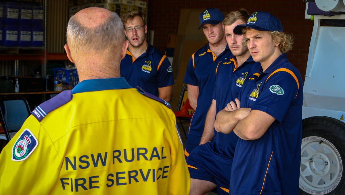 Brumbies players listen to a member of the NSW Rural Fire Service. Picture: Brumbies Media