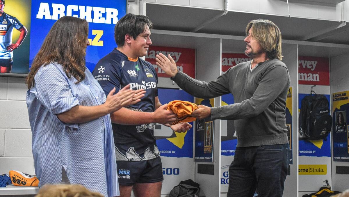 Dianne and Russell Holz present Archer with his first Brumbies jersey. Picture: Lachlan Lawson/Brumbies Media