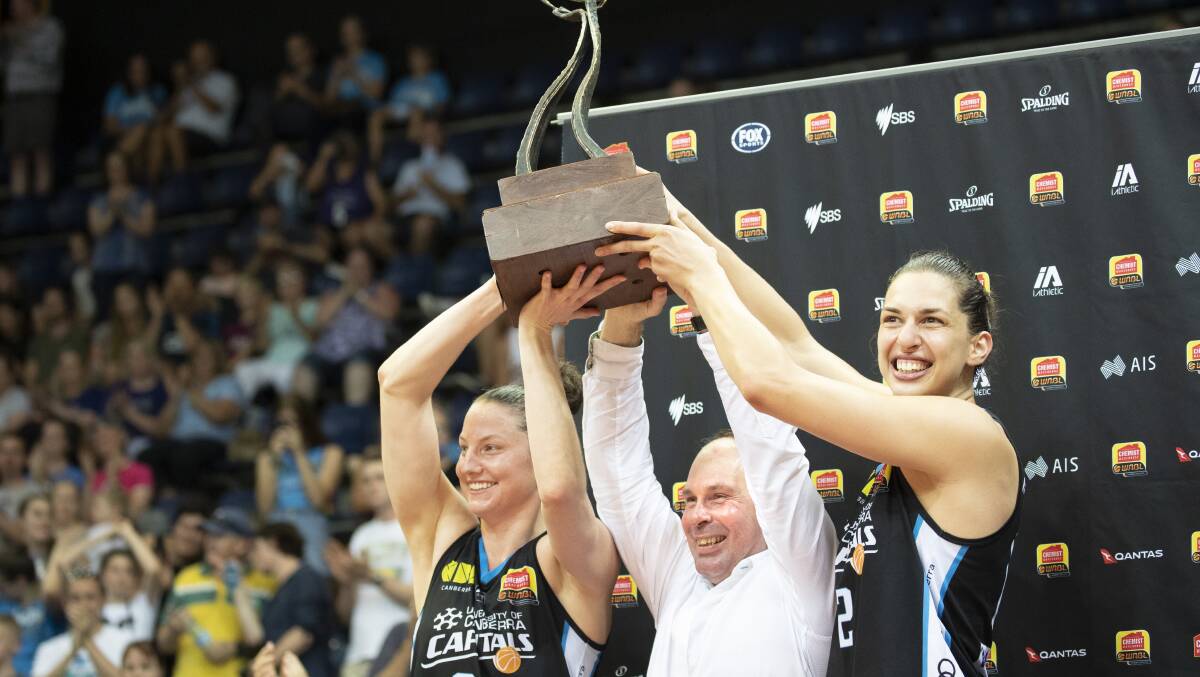 The Canberra Capitals' Kelsey Griffin, Paul Goriss, and Marianna Tolo hoist the WNBL championship trophy in the 2018-19 season. Picture: Sitthixay Ditthavong