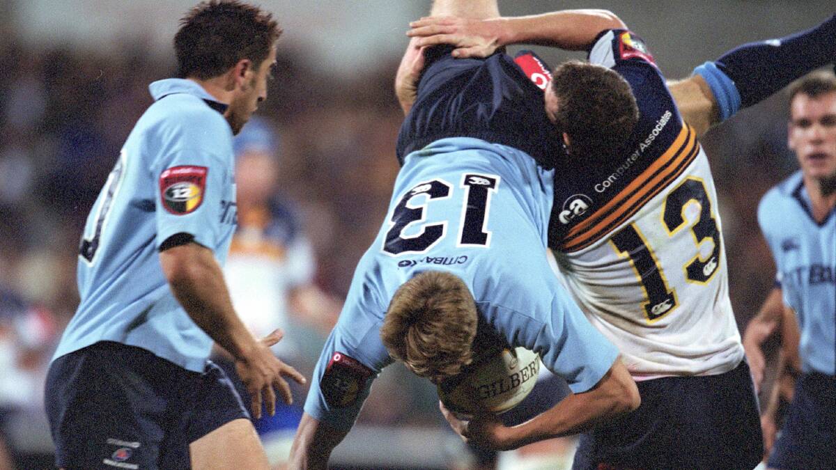 Luke Inman of the Waratahs is tackled by Brumbies counterpart Stirling Mortlock during the Super 12 era. Picture: Getty