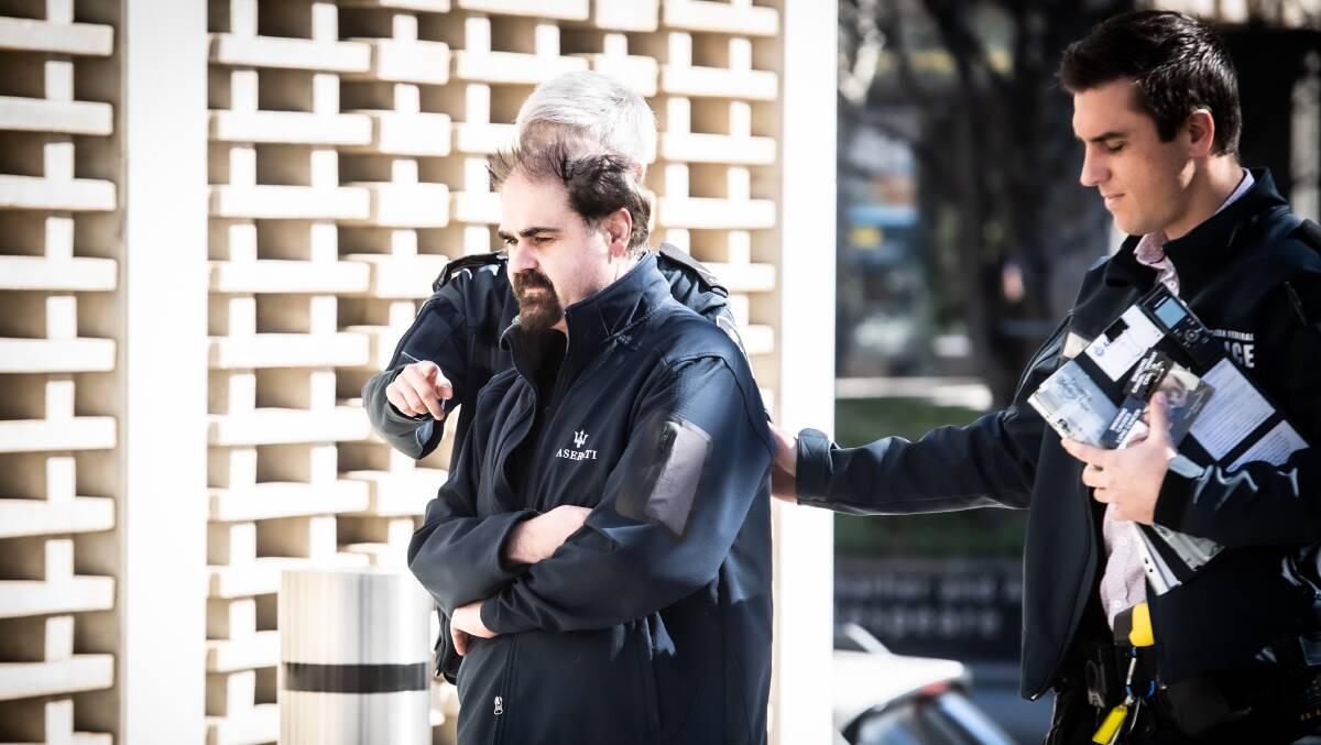 Detectives lead Courgette owner James Mussillon, left, into City Police Station after his arrest. Picture: Karleen Minney