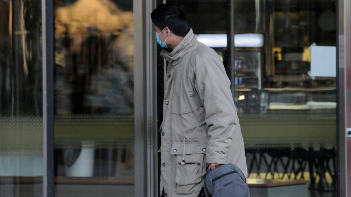 Junqi Huang hides his face as he leaves court on Friday. Picture: Blake Foden