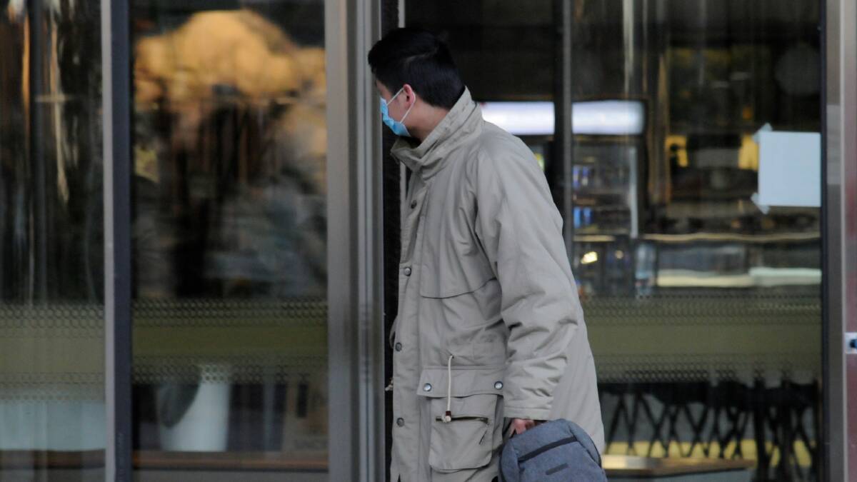 Junqi Huang hides his face outside court. Picture: Blake Foden