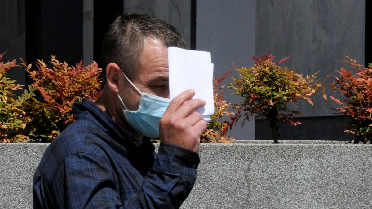 Jai Glover hides behind a piece of paper while leaving court on Thursday. Picture: Blake Foden