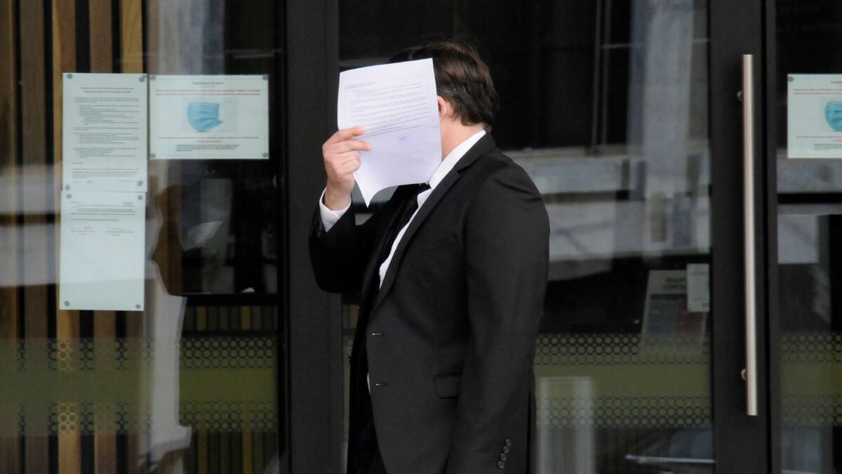Nathan Knight hides behind a piece of paper outside court. Picture: Blake Foden
