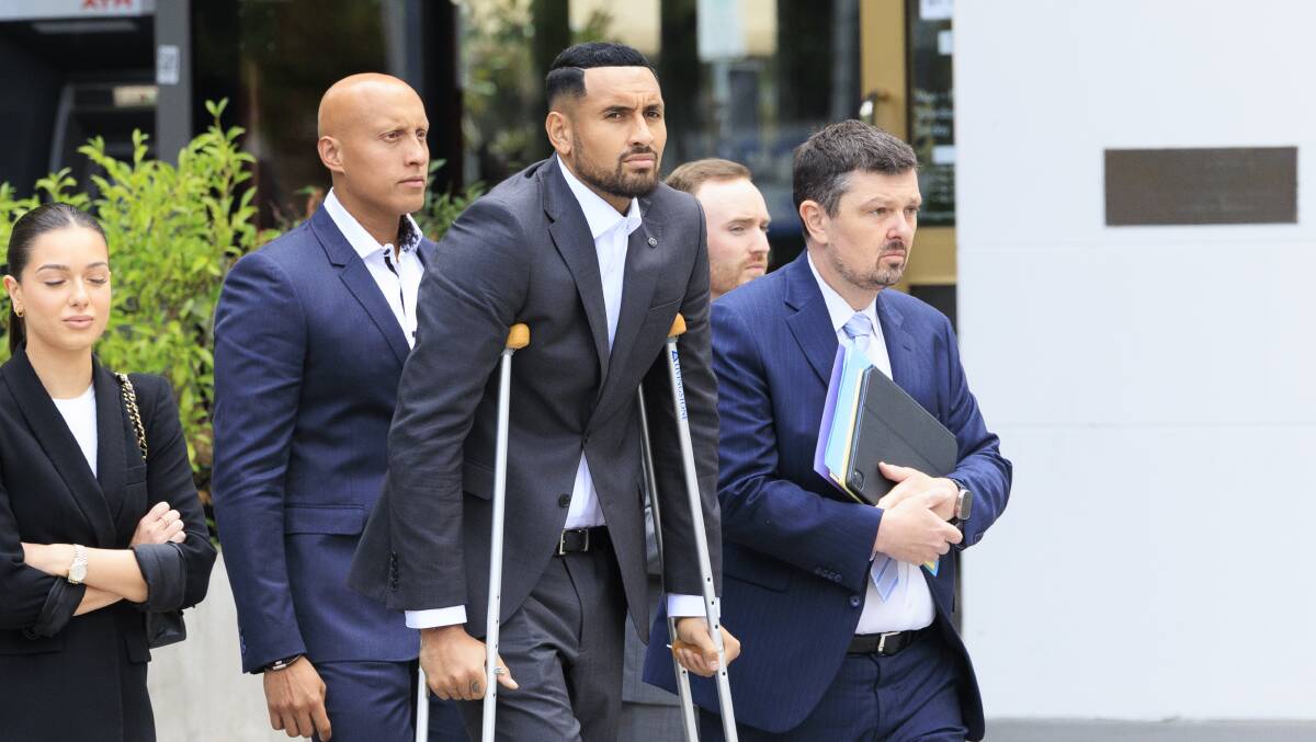 Nick Kyrgios hobbles to court with his lawyer and supporters. Picture by Keegan Carroll