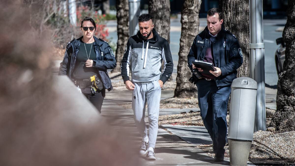 Officers escort Mohammed Al-Mofathel, centre, into City Police Station on the day of his arrest. Picture: Karleen Minney