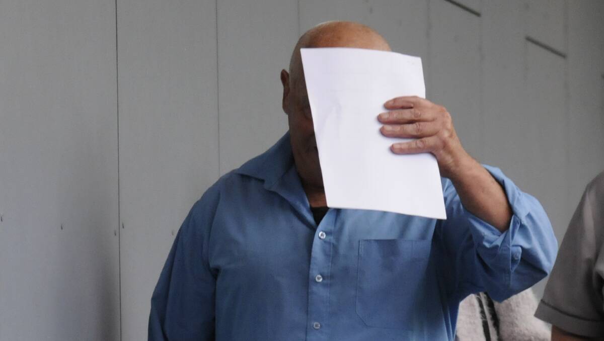 Peter Van Dyk tries to hide behind a piece of paper despite his face having already been photographed outside court. Picture by Blake Foden