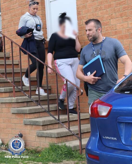 Investigators take a woman into custody in Queanbeyan. Picture: NSW Police