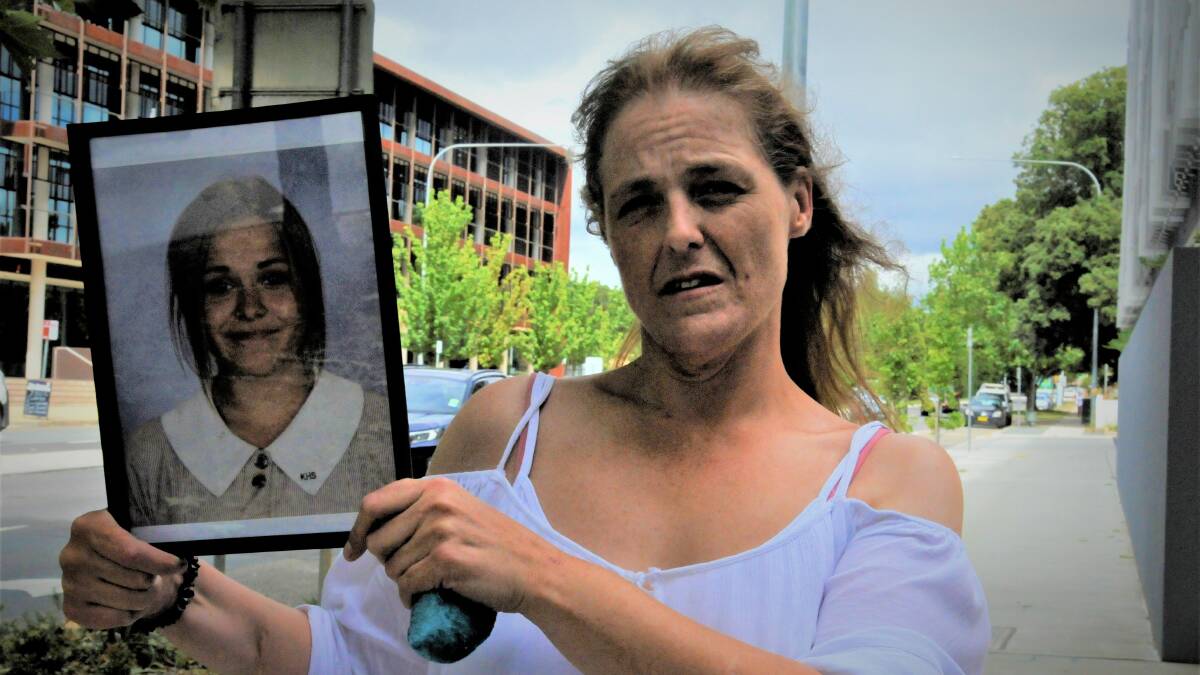 Charli Powell's mother, Sharon Moore, displays a photograph of her outside the Queanbeyan courts. Picture: Blake Foden