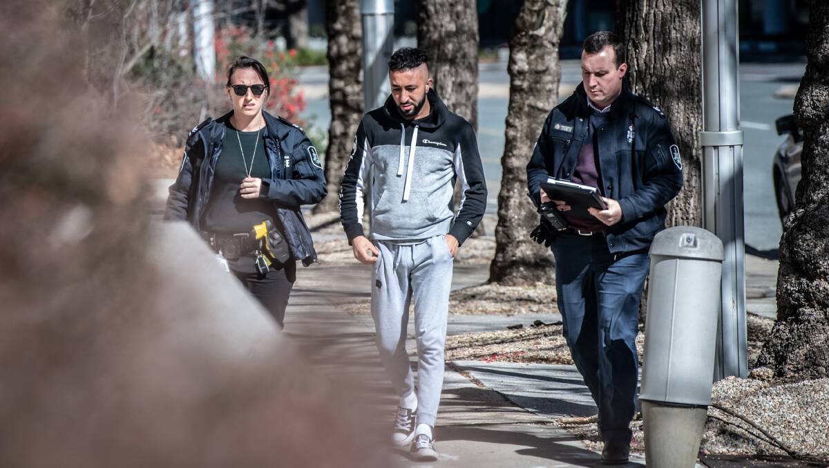 Officers escort Mohammed Al-Mofathel, centre, into City Police Station after his arrest. Picture by Karleen Minney