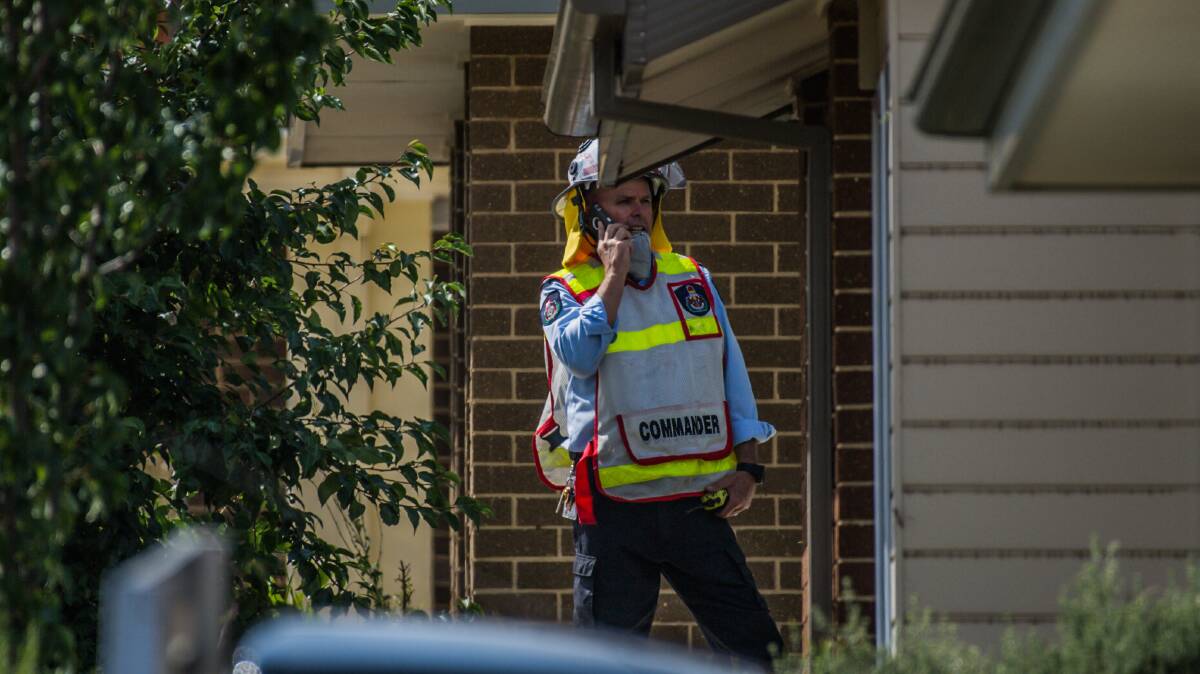A senior firefighter makes a phone call outside the Bonner home. Picture: Karleen Minney