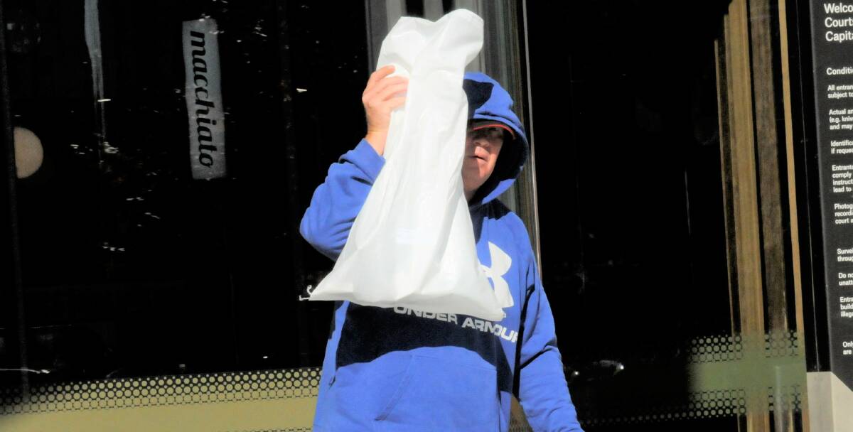 Kevin Malone hides his face while hurling abuse outside court. Picture: Blake Foden