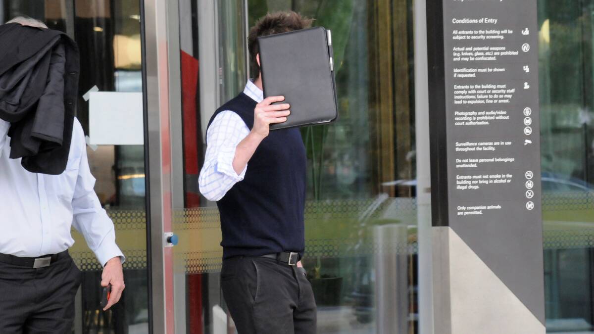 Steven Black hides behind a folder outside court last year. Picture: Blake Foden