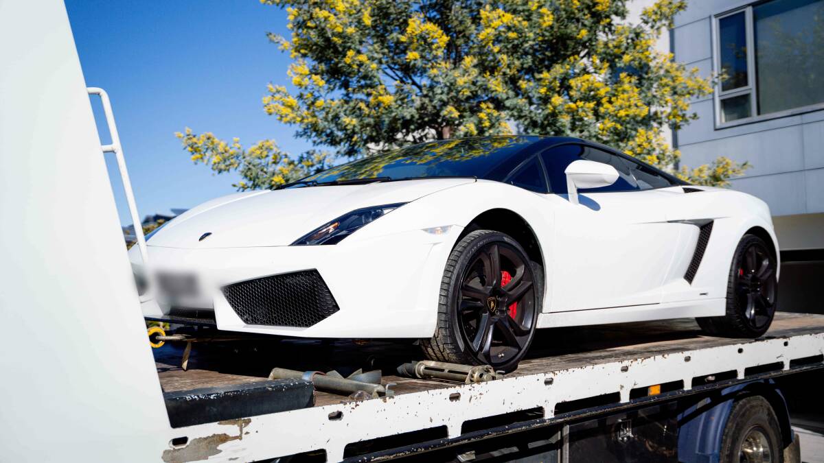 The restrained Lamborghini is loaded onto a truck during police raids on Thursday. Picture: ACT Policing