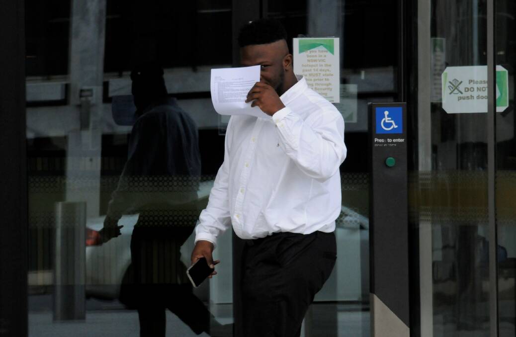 Emmanuel Umunakwe tries to hide his face outside court before thinking better of the idea. Picture: Blake Foden
