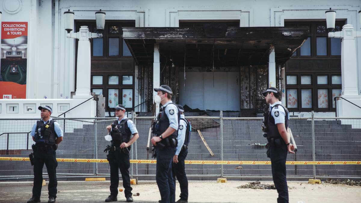 Police officers stand guard outside a damaged Old Parliament House the day after the fire. Picture: Dion Georgopoulos