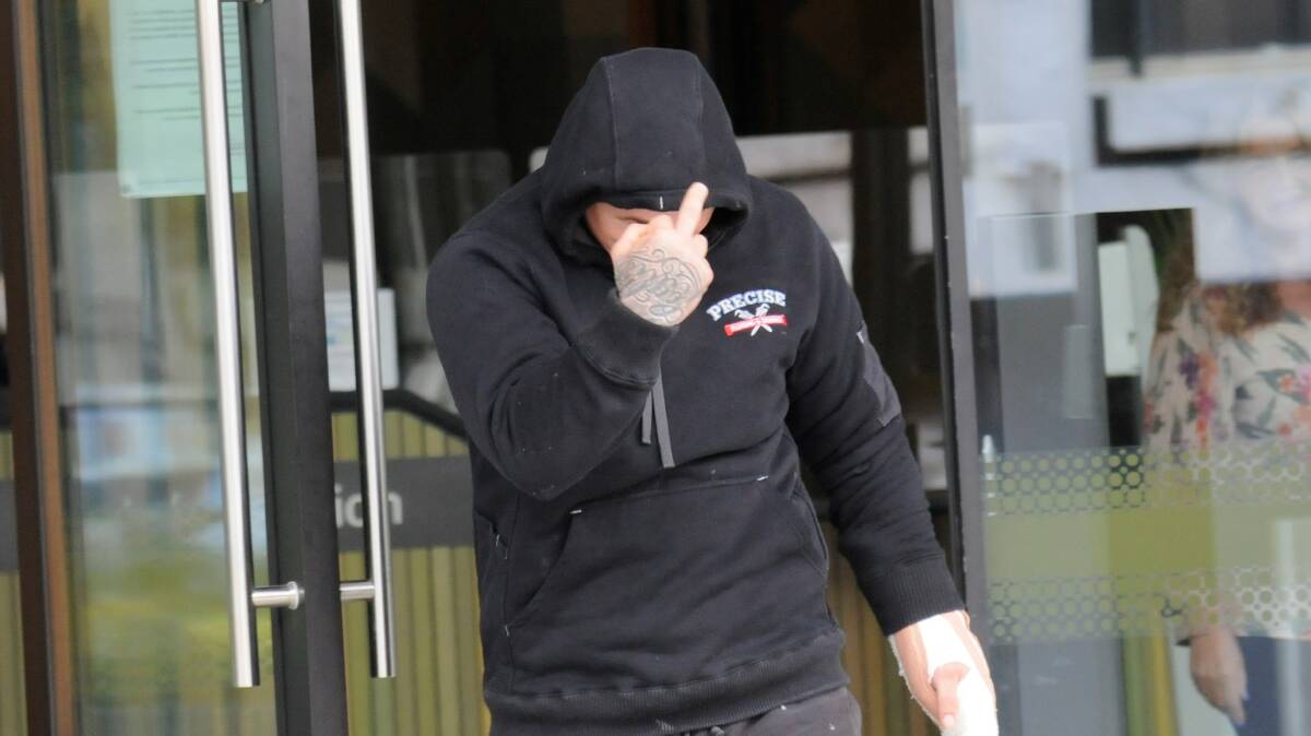 Shane Houghton flips the bird outside court on Monday. Picture by Blake Foden