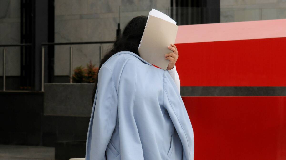Loretta Tulikaki shields her face outside court on a previous occasion. Picture: Blake Foden
