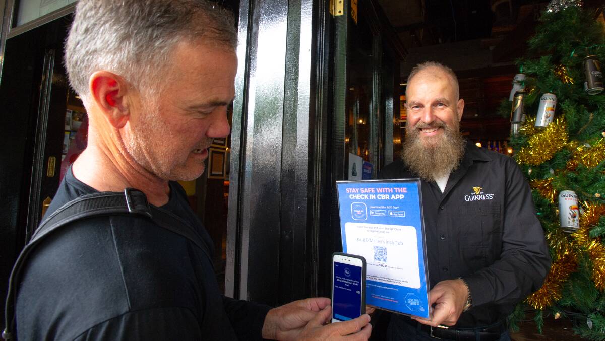 King O'Malley's owner Peter Barclay (right) signs in Giulio Cerasani of Weston using the pubs' QR code. Picture: Elesa Kurtz 