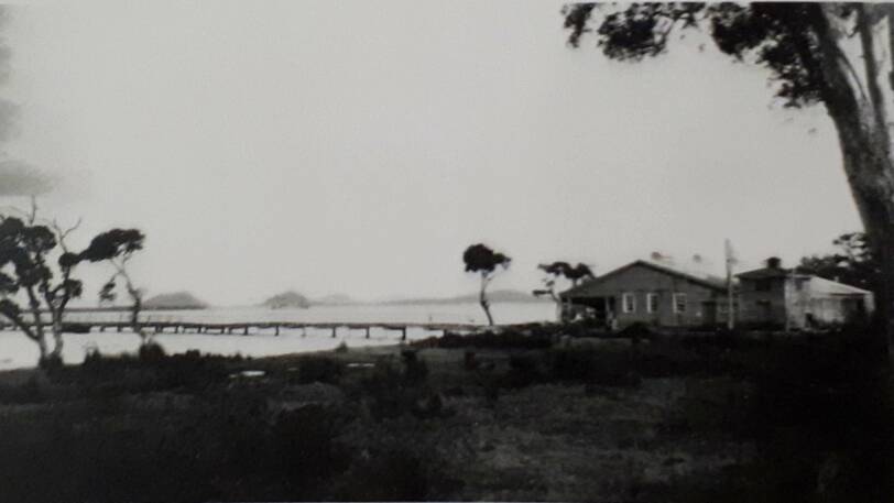 A CENTURY AGO: The building to the right is the shark processing factory at Pindimar, near Tea Gardens, which operated from 1927 to 1938, with the building burning down in 1938. The distinctive heads of Port Stephens, Yacaaba and Tomaree, can be seen across the water to the left of the picture.