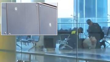 A screenshot of a video showing a man arrested at Canberra Airport. Inset, where bullets appear to have struck the glass. Pictures: Facebook/Walter Olson and Keegan Carroll