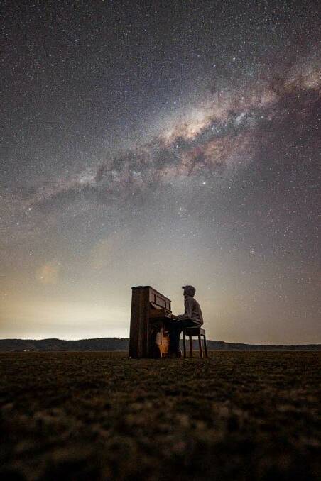 Alex Johnston plays a piano under a blanket of stars at Lake George. Picture: Alex Johnston - Photography Facebook page @AlexJohnstonmedia