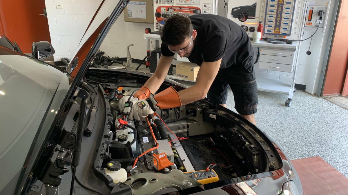 CIT graduate Sid Gonzalez-Obst disconnects the secondary battery on a Tesla 3 to diagnose an air-conditioning fault. Picture by Peter Brewer