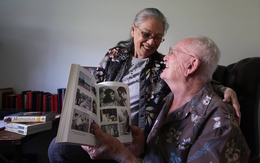 Kim Dung and Carl Robinson share a laugh over their photo in the book The Bite of the Lotus. Picture: Sylvia Liber