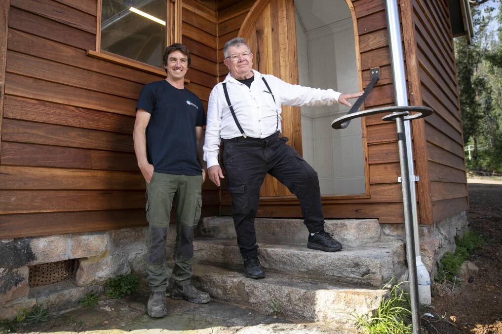 Builder Peter Jirgens with Mogo potter and painter Peter Williams and the rebuilt Mogo church. Photo: Keegan Carroll